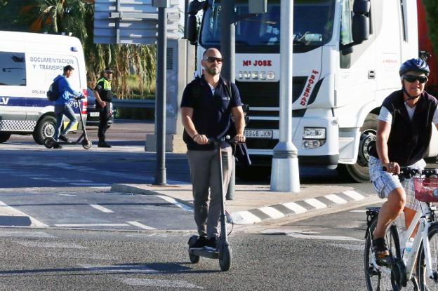 Un usuario de patinete discurre por un carril bici. 