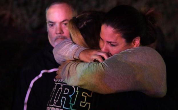 Una mujer que ha huido del tiroteo es consolada.