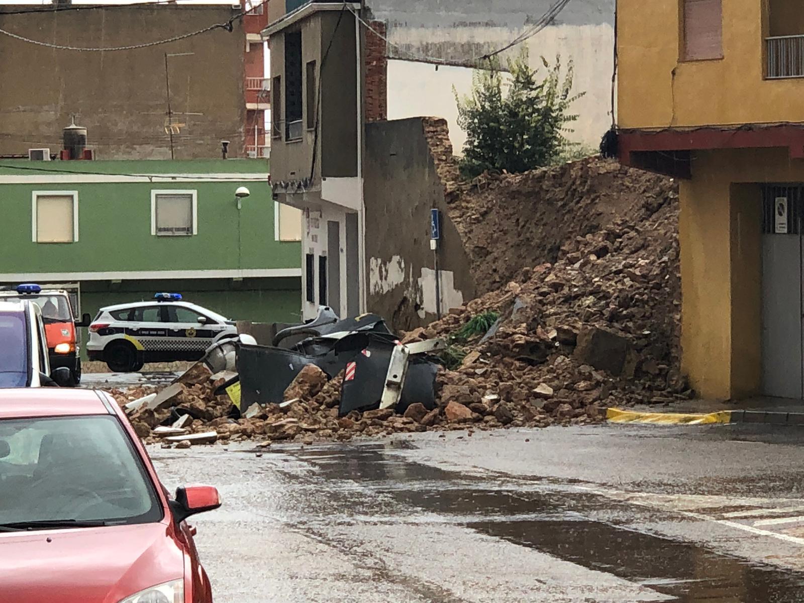 La acumulación de agua en Montserrat durante las últimas horas ha provocado el desprendimiento de tierra en un solar cercano al centro de salud. Este incidente no ha causado daños pero el muro antiguo que se encontraba en este solar ha cedido y la tierra y las piedras han llegado a la calle.