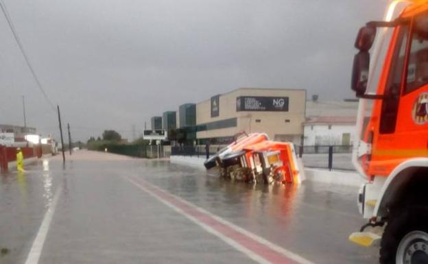 Camión de bomberos volcado.