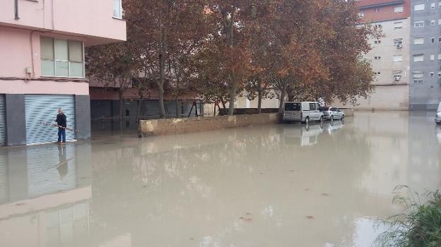 Un vecino de la plaza Músico Antonio Eiximeno, ayer junto a la zona inundada de esta parte de la Malvarrosa. 