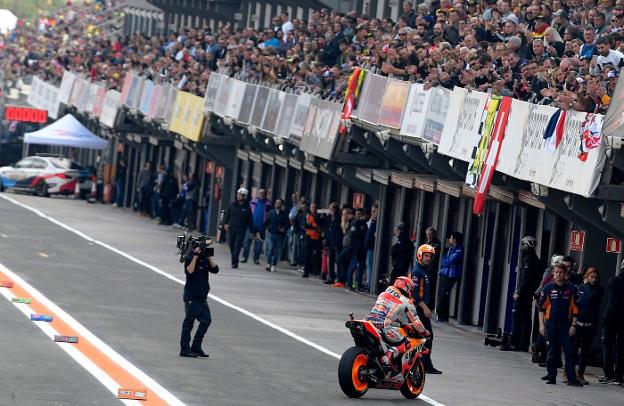 Márquez entra en el box de Honda bajo la grada repleta de aficionados. 