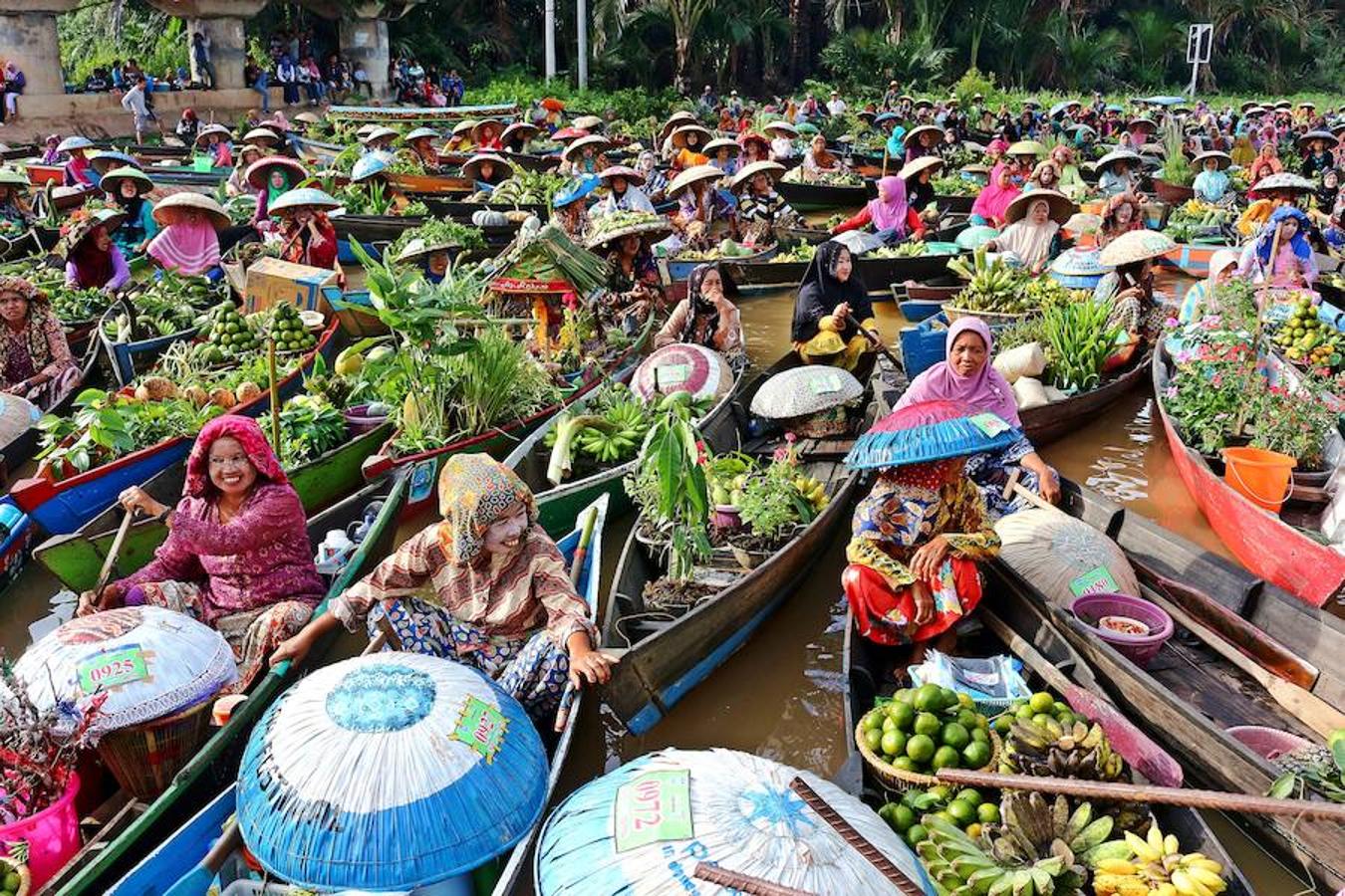 Lok Baintan (Indonesia) | El comercio local de la localidad indonesia de Banjarmasin, también conocida como el 'lugar de los mil ríos', discurre sobre las aguas del Martapura. Las mujeres son las dueñas del lugar: dirigen sus barcas, se encargan de la mercancía, de la compra y de la venta, formando una auténtica marea mercantil de color.