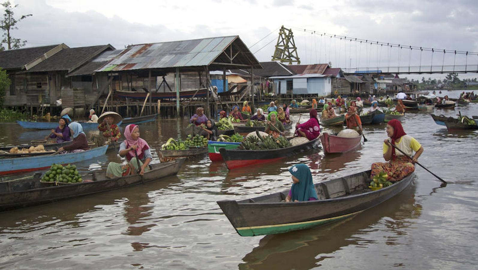 Lok Baintan (Indonesia) | El comercio local de la localidad indonesia de Banjarmasin, también conocida como el 'lugar de los mil ríos', discurre sobre las aguas del Martapura. Las mujeres son las dueñas del lugar: dirigen sus barcas, se encargan de la mercancía, de la compra y de la venta, formando una auténtica marea mercantil de color.