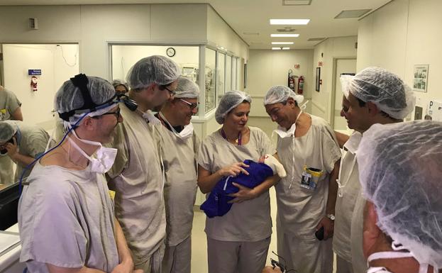 El equipo médico sostiene al primer bebé nacido a través de un trasplante de útero de una donante fallecida, en el hospital de Sao Paulo.