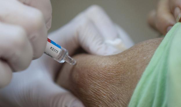 Un médico vacuna de la gripe a un paciente. 