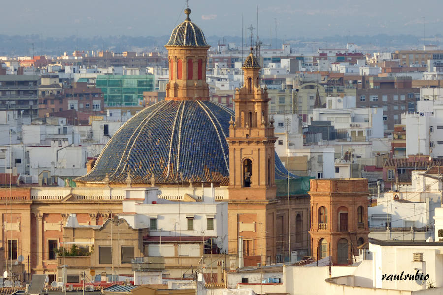 Valencia nunca deja de sorprender. Es habitual la imagen desde la calle de los múltiples campanarios que se encuentran en la ciudad. En el centro histórico aún encontramos más torreones eclesiásticos. Pero, ¿cómo se ve la ciudad desde el cobijo de las campanas?. Raúl Rubio, de la Associació de Mestres Campaners, ha inmortalizado esa visión de la que poca gente puede disfrutar: Valencia desde sus campanarios. Ver la plaza de San Agustín con una perspectiva diferente, contemplar el centro de la ciudad desde Santa Catalina, admirar Valencia desde las campanas del Real Monasterio de la Santísima Trinidad son algunos de las panorámicas exquisitas casi exclusivas para campaneros. La ciudad se redescubre desde las alturas, desde la perspectiva de gárgolas, campanas y tejados. Así es Valencia desde sus campanarios.