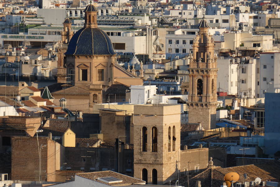 Valencia nunca deja de sorprender. Es habitual la imagen desde la calle de los múltiples campanarios que se encuentran en la ciudad. En el centro histórico aún encontramos más torreones eclesiásticos. Pero, ¿cómo se ve la ciudad desde el cobijo de las campanas?. Raúl Rubio, de la Associació de Mestres Campaners, ha inmortalizado esa visión de la que poca gente puede disfrutar: Valencia desde sus campanarios. Ver la plaza de San Agustín con una perspectiva diferente, contemplar el centro de la ciudad desde Santa Catalina, admirar Valencia desde las campanas del Real Monasterio de la Santísima Trinidad son algunos de las panorámicas exquisitas casi exclusivas para campaneros. La ciudad se redescubre desde las alturas, desde la perspectiva de gárgolas, campanas y tejados. Así es Valencia desde sus campanarios.