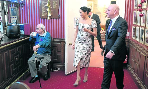 La duquesa de Sussex recorre las instalaciones mientras Richard O'Sullivan, protagonista de la serie 'Un hombre en casa', toma un té. 