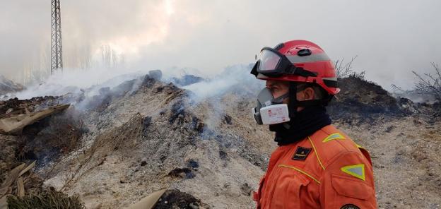 Un bombero, ayer, entre las montañas de residuos humeantes del incendio de Sollana. 