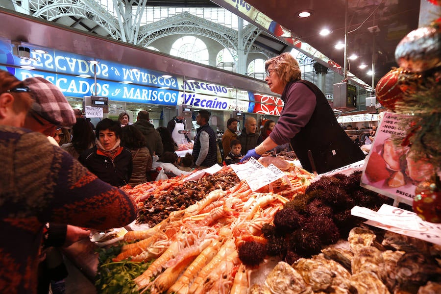 Lleno hasta la bandera. Así ha estado este sábado el centro de Valencia con curiosos que querían fotografiar todos los escaparates, pero sobre todo con gente haciendo las compras de Nochevieja. Uno de los puntos de encuentro que ha registrado el cartel de 'completo' ha sido una vez más el Mercado Central. El marisco, salazones, frutos secos y quesos variados llenan las cestas a dos días del Fin de Año. 