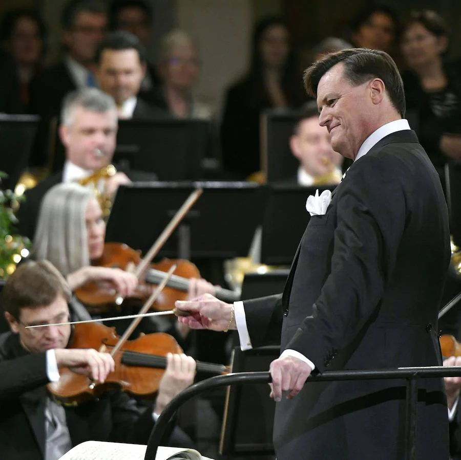 El maestro alemán Christian Thielemann ha dirigido por primera vez a la Orquesta Filarmónica de Viena en el Concierto de Año Nuevo, que este año alcanza su 78ª edición y en el que se han interpretado célebres piezas de la dinastía Strauss, de Carl Michael Ziehrer y de Josef Hellmesberger Jr., y las tradicionales 'El Danubio Azul' o la 'Marcha Radetzky'. Desde la Sala Grande o Dorada del Musikverein de Viena, la Filarmónica ha deleitado al público en la primera parte del concierto, con la 'Marcha Schönfeld' de Carl Michael Ziehrer; el vals 'Transacciones' de Josef Strauss; la 'Danza de los elfos' de Josef Hellmesberger Jr.; la polca rápida 'Exprés' y el vals 'Estampas del Mar del Norte' de Johann Strauss hijo; y la polca rápida 'Con franqueo extra' de Eduard Strauss. En la segunda, la obertura de la opereta 'El barón gitano' de Johann Strauss y la polca francesa 'La bailarina' de Josef Strauss; a continuación, el vals acompañado de ballet 'Vida del artista' yla polca rápida 'La bayadera' de Johann Strauss hijo; la polca francesa 'Noche de ópera' de Eduard Strauss; el 'Vals de Eva' y 'Zarda' con el ballet, de la ópera 'Caballero Pásmán' de Johann Strauss hijo; la 'Marcha egipcia' también de Johann Strauss hijo; el vals 'Entreacto' de Josef Hellmesberger Jr.; la polca mazurca 'Elogio a las mujeres' de Johann Strauss hijo; y el vals 'Música de las esferas' de Josef Strauss. El concierto finaliza con varios bises. El maestro Christian Thielemann y los músicos han tocado el vals 'El Danubio Azul' de Johann Strauss hijo, a continuación han felicitado el Año Nuevo y se han despedido con la 'Marcha Radetzky' de Johann Strauss padre. El programa del intervalo musical entre las dos partes del concierto se titula 'Ópera Estatal de Viena: 150 aniversario' y ofrece un recorrido musical por su sede, con motivo de sus 150 años. Selectos grupos de la Filarmónica de Viena, así como cantantes, bailarines y el coro de la Ópera Estatal, actúan en varios lugares dentro y alrededor del Teatro de la Ópera, que fue inauguradoen 1869 por el emperador Francisco José I. Además, el Ballet Estatal de Viena ha intervenido en varias ocasiones con coreografías del ruso Andrey Kaydanovskiy.