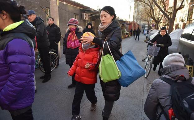 Una madre saca a su hijo de la escuela tras el ataque. 