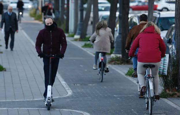 Un usuario de patinete recorre el carril bici en una calle de Valencia. 