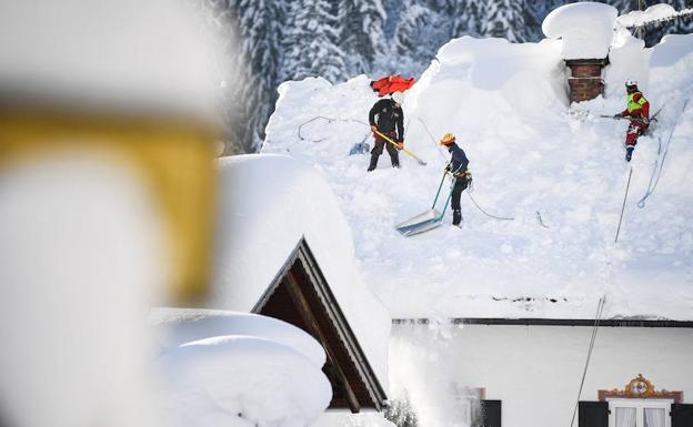 Operarios retiran la nieve de un tejado en Gerold (Alemania). 