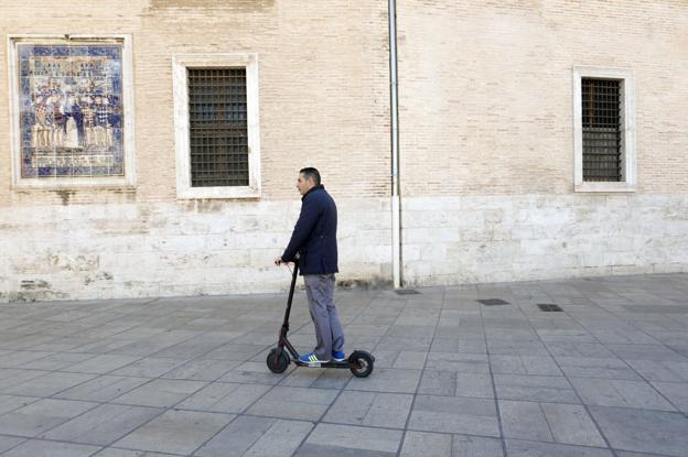 Un usuario de patinete circula por una zona peatonal en el centro de Valencia. 