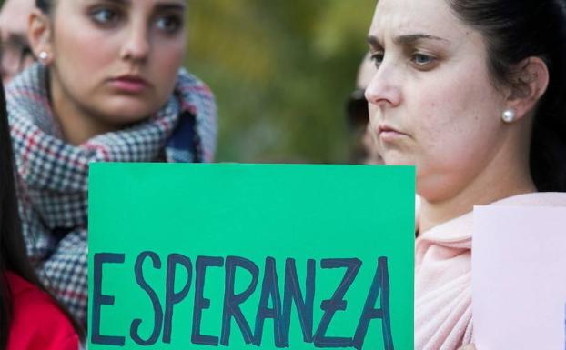 Dos mujeres, con un cartel en apoyo a Julen. 