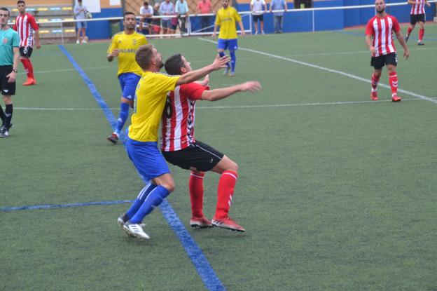 Jordi disputando un balón con un jugador de L'Alcúdia. 
