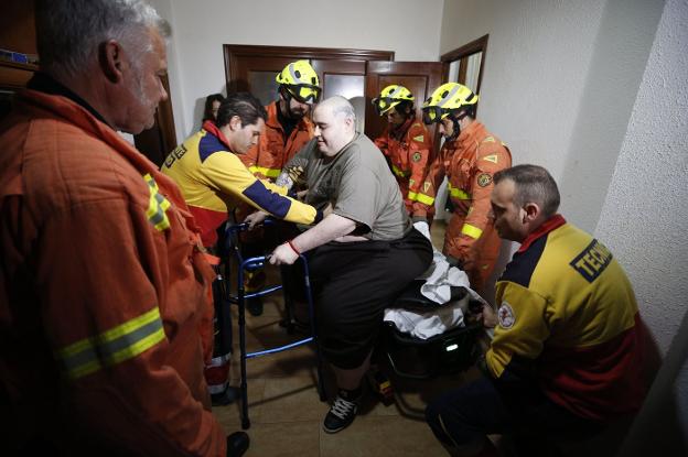 Teo recibe ayuda de los bomberos para entrar en su casa tras dejar el Hospital de Manises. 