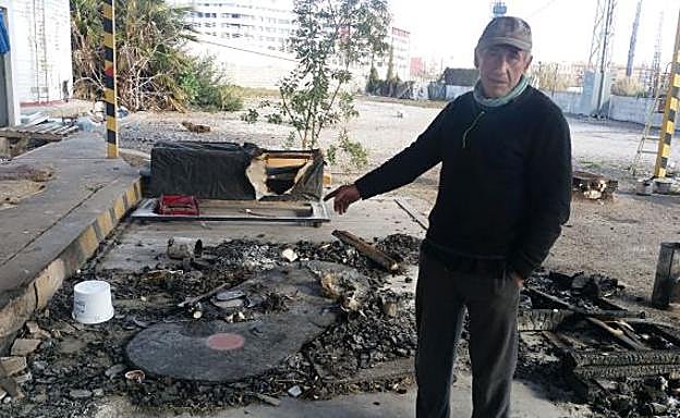Nico señala los restos de los enseres quemados por el hombre que incendió la puerta de la vivienda.
