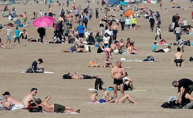 Un gran número de personas se ha acercado este sábado a la playa de la Malavarrosa para disfrutar del día soleado. 