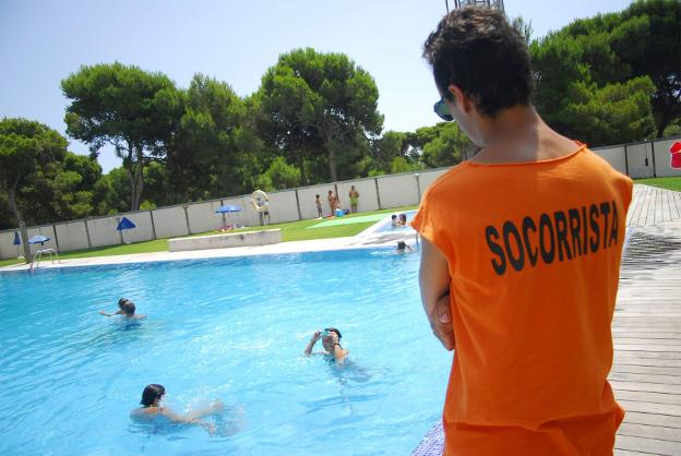 Un socorrista vigila una piscina. 