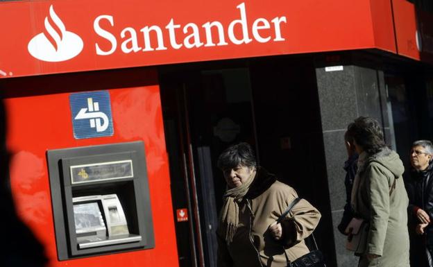 Clientes retiran dinero del cajero autómatico de una sucursal del Banco Santander. 