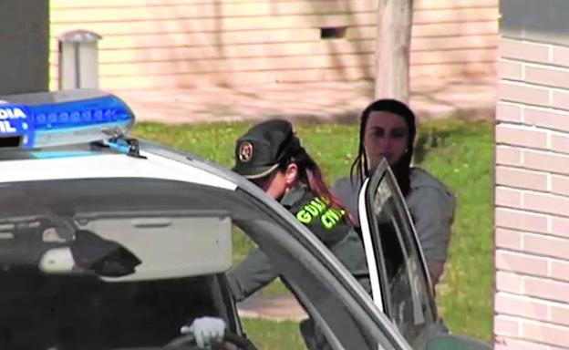 Un guardia civil conduce al coche policial a la madre de los niños. 