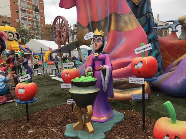 Una hechicera remueve un caldero en Prado ante carteles de promesas incumplidas por los políticos. 