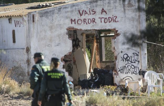 Agentes de la Guardia Civil inspeccionan el lugar del doble infanticidio. En la pared, la inscripción del cortometraje. 