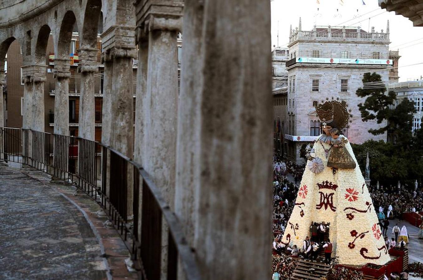 La Ofrenda concluyó este lunes después de que miles de falleros desfilaran para llevar las flores a la Virgen de los Desamparados. Este martes, a la luz del día se ha desvelado ante los ojos de los valencianos el aspecto definitivo del manto de la 'Geperudeta'. Claveles blancos, rojos y rosas componen componen el diseño del vestidor Rafael Chordá. Un floreado manto con el blanco como color predominante y que preside estos días la plaza de la Virgen, ante su basílica.