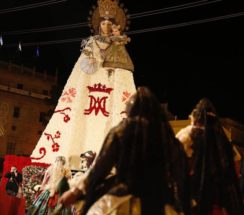 La Ofrenda concluyó este lunes después de que miles de falleros desfilaran para llevar las flores a la Virgen de los Desamparados. Este martes, a la luz del día se ha desvelado ante los ojos de los valencianos el aspecto definitivo del manto de la 'Geperudeta'. Claveles blancos, rojos y rosas componen componen el diseño del vestidor Rafael Chordá. Un floreado manto con el blanco como color predominante y que preside estos días la plaza de la Virgen, ante su basílica.