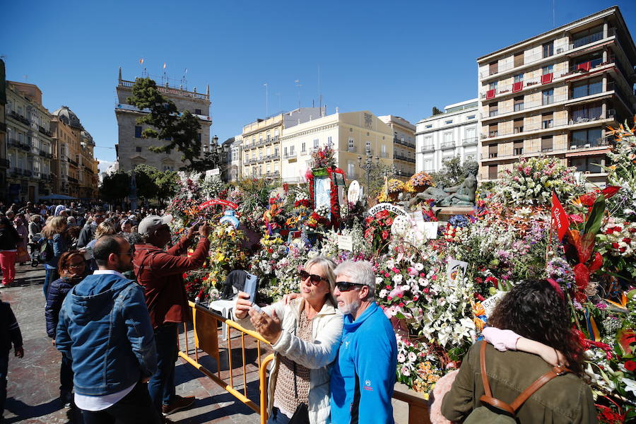 La Ofrenda concluyó este lunes después de que miles de falleros desfilaran para llevar las flores a la Virgen de los Desamparados. Este martes, a la luz del día se ha desvelado ante los ojos de los valencianos el aspecto definitivo del manto de la 'Geperudeta'. Claveles blancos, rojos y rosas componen componen el diseño del vestidor Rafael Chordá. Un floreado manto con el blanco como color predominante y que preside estos días la plaza de la Virgen, ante su basílica.