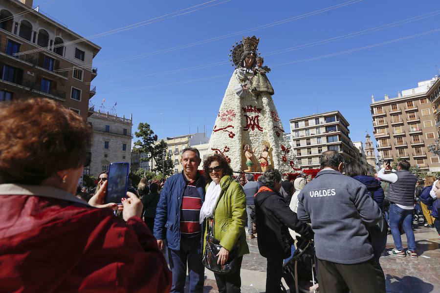 La Ofrenda concluyó este lunes después de que miles de falleros desfilaran para llevar las flores a la Virgen de los Desamparados. Este martes, a la luz del día se ha desvelado ante los ojos de los valencianos el aspecto definitivo del manto de la 'Geperudeta'. Claveles blancos, rojos y rosas componen componen el diseño del vestidor Rafael Chordá. Un floreado manto con el blanco como color predominante y que preside estos días la plaza de la Virgen, ante su basílica.