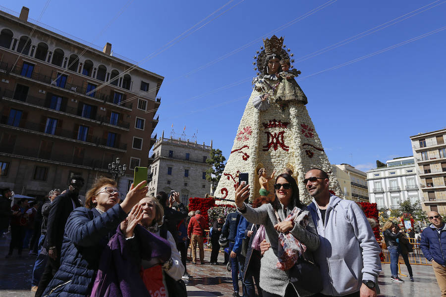 La Ofrenda concluyó este lunes después de que miles de falleros desfilaran para llevar las flores a la Virgen de los Desamparados. Este martes, a la luz del día se ha desvelado ante los ojos de los valencianos el aspecto definitivo del manto de la 'Geperudeta'. Claveles blancos, rojos y rosas componen componen el diseño del vestidor Rafael Chordá. Un floreado manto con el blanco como color predominante y que preside estos días la plaza de la Virgen, ante su basílica.