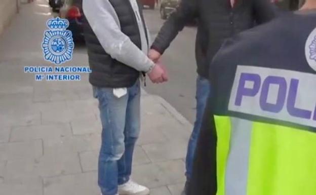 La Policía Nacional esposa a uno de los detenidos.