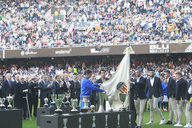 Kempes, Parejo y Jaume portan la bandera del Valencia ante los trofeos logrados por el club en su centenaria historia.