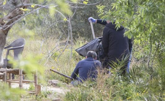 Los agentes recogen dos palos en la escena del crimen. 