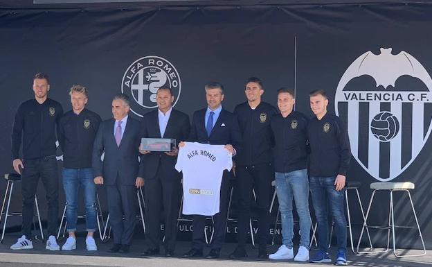 Anil Murthy y varios jugadores del Valencia posan junto a los representantes de Alfa Romeo.