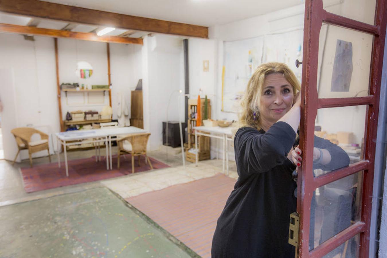 Hace tres años Antonia Martínez, alicantina residente en Rocafort, comenzó a trabajar en obras de mayor volumen. Fue en ese momento cuando se dio cuenta de que el estudio que tenía entonces se le quedaba pequeño e inició una búsqueda marcada con dos premisas: que el lugar tuviera mucha luz y una terraza. «Quería algo abierto y luminoso que tuviera una terraza, pues me apetecía tener ese pequeño desahogo. Encontré este espacio que había albergado una serrería, estaba todo lleno de serrín y las paredes y el techo estaban pintadas de un azul intenso», explica Antonia Martínez, artista plástica y diseñadora. El espacio está repartido en dos plantas que difieren en cuanto a incidencia solar. La luz del piso de arriba es muy distinta a la de abajo, allí tiene el patio pero la luz no le llega de la calle. Por ello, utiliza focos para abordar trabajos que requieren de más detalle. «Arriba, en cambio, me dedico a pintar. Cuando son obras de gran tamaño grapo la tela a la pared, suelo pintar aquellas que han sido utilizadas como sábanas antiguas que encuentro o me regala alguna amiga. Me gusta el hecho de que tengan una historia detrás». Además de su labor como artista, hace diez años que Antonia colabora con la Fundación Neurocirugía y Desarrollo, una labor que lleva a cabo con un grupo de mujeres en Zanzíbar, uno de los lugares del planeta donde más casos hay de hidrocefalia infantil. «Les enseño a pintar o a trabajar con orfebrería para que puedan vivir de su trabajo, es una labor muy gratificante», explica la artista. «Este lugar me ha aportado libertad en el sentido de que puedo utilizar cualquier espacio conforme lo necesito. Godella es un pueblo tranquilo que a la vez tiene vida y mucha tradición artística. Estar a pie de calle y que la gente te pueda visitar es muy interesante». 