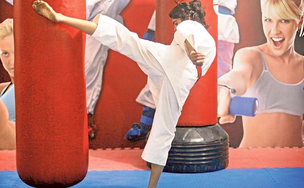 Una joven practica artes marciales en un gimnasio.