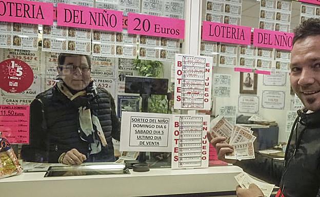 Un hombre, con varios décimos de lotería, en una administración.