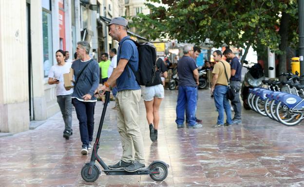 Patinete circulando por la acera.