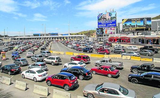 Paso fronterizo en Tijuana, con vallas publicitarias entre las que destaca una clínica de cirugía estética.