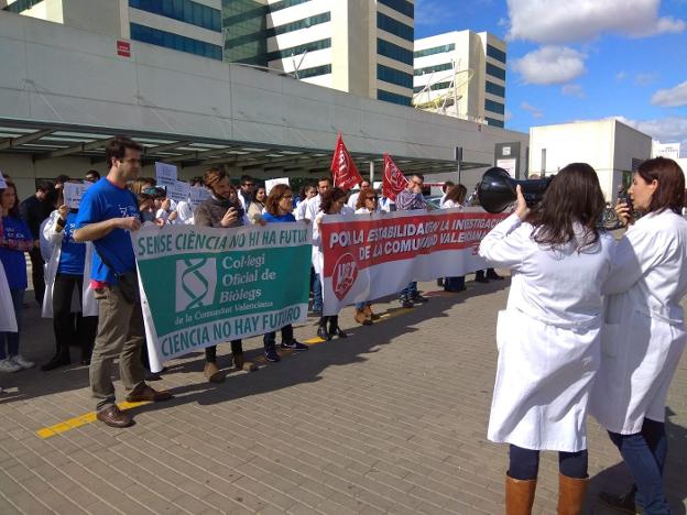 Decenas de investigadores protestan a las puertas del Hospital La Fe, ayer. 