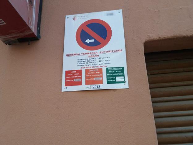 Una placa de reserva de espacio para la terraza, en una calle de Xirivella, con fecha del año pasado. 