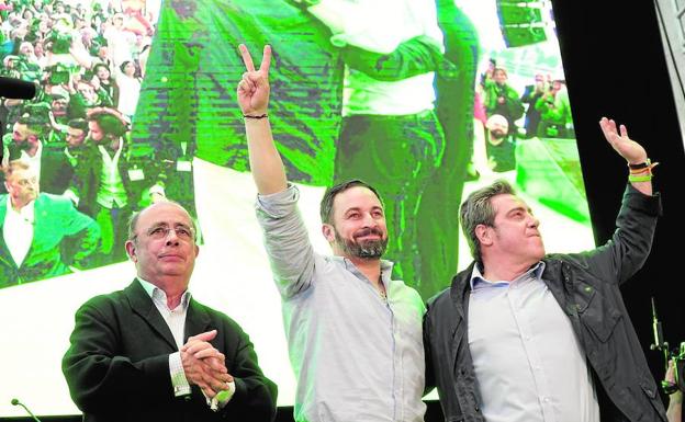 Ignacio Gil Lázaro, Santiago Abascal y José María Llanos saludan en un momento del mitin. 