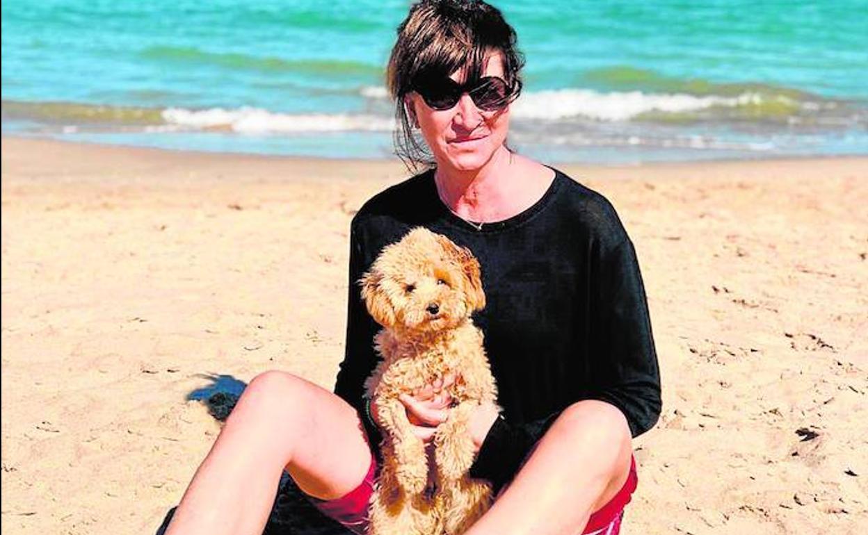 Carmen con su perrita en la playa, uno de los lugares que más le gustan.