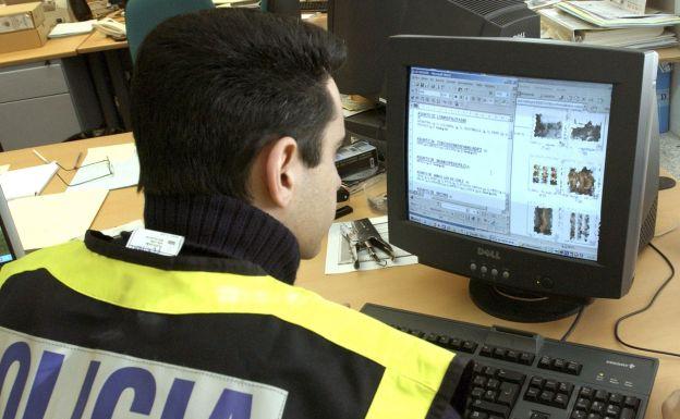 Policía registrando un ordenador en una operación contra la pedofilia.