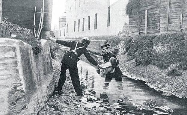 Una pareja de guardias civiles en unas inundaciones en el año 1900.